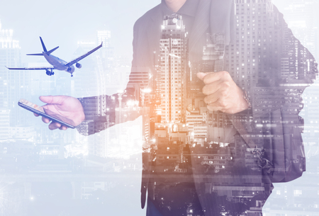 Businessman looking smartphone with double exposure city and airplane, concepts of business communication technology and Business concept airlineの写真素材