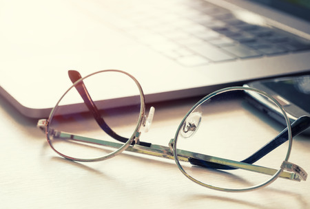 Eyeglasses with Laptop on bright light background