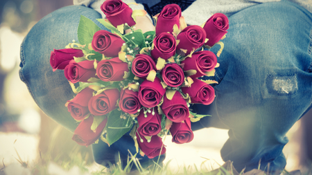 Woman holding rose flower in vintage style backgroundの写真素材