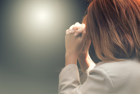 Woman hands praying in the darkの写真素材