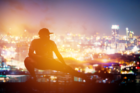 Silhouette fitness at sunset in blurred cityscapeの写真素材