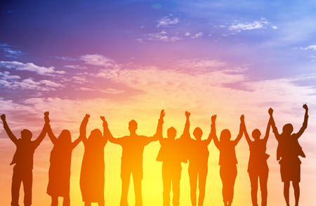 Silhouette of happy business team making high hands in sunset sky background for business teamwork...