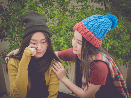 Young girl cry and her friend comfort her.の写真素材