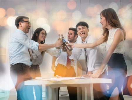 Businessmen are celebrating. After the big project succeeded. On blurred bokeh backgroundの写真素材