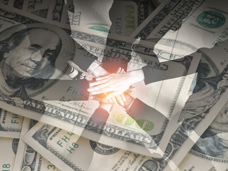 Concept of teamwork,business six worker joined hands on money background (grain in picture)の写真素材