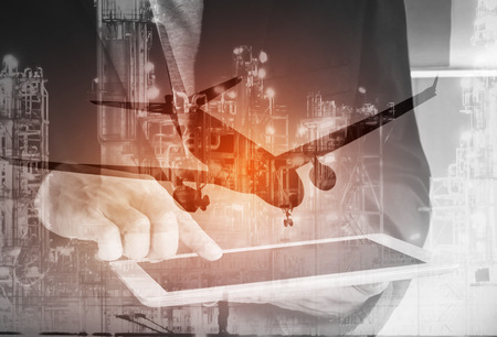 Double exposure of businessman hand hold tablet and oil refinery industry plant with airplane, Petroleum energy for conceptの写真素材