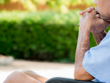 Lonely sickman in his 77 years old sitting in wheelchair at parks near house. Family concept.の写真素材