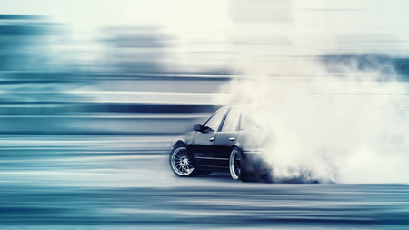 Car drifting, Blurred of image diffusion race drift car with lots of smoke from burning tires on speed trackの写真素材