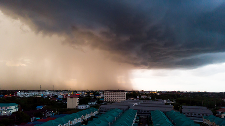 Rainy storm with grain over the city. Dark sky and dramatic cloud before rain in rainy season.
