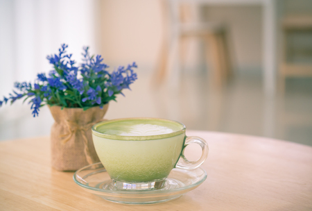 Cup of green tea milk with flower on desk at coffee shop.(selective focus)の写真素材