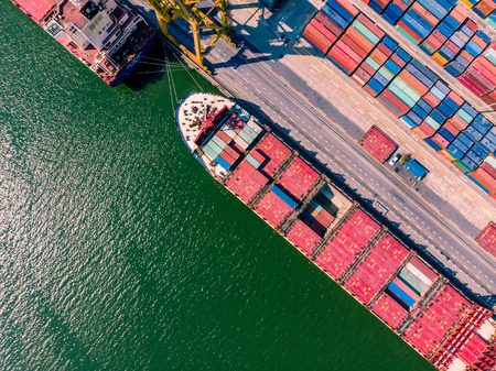 Aerial view of cargo ship loading container and cargo plane. Logistics and transportation of...