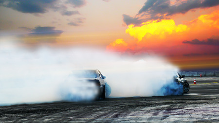 Blur of two drifting cars battle on speed track at sunset. Motorsport concept.の写真素材