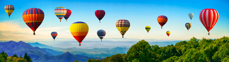 Panorama of mountain with hot air balloons on morning at Thailand.の写真素材