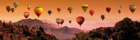 Hot air balloon above high mountain at sunsetの写真素材