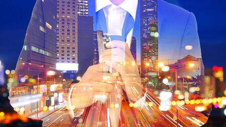 Double exposure image of businessman in suit Remove the necktie with the traffic image in the city at night.の写真素材