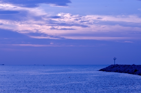 Dramatic sunrise over rocky breakwater  in Thailandの写真素材