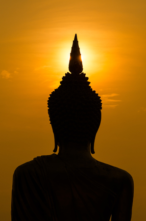 Flare over Silhouette of Buddha statue in Thailandの写真素材