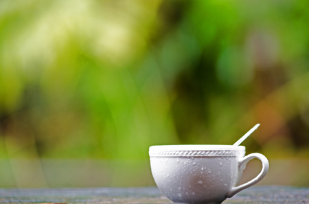 White cup of coffee stay against raindrop