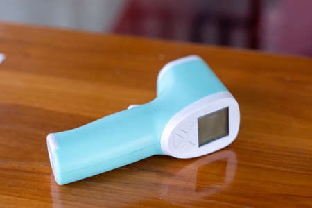 infrared thermometer isolated on wooden background to measure a body temperature.の写真素材