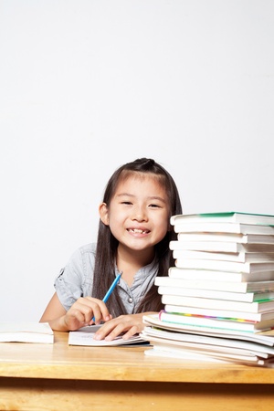 Portrait of cheerful Asian young girl doing her homework の写真素材