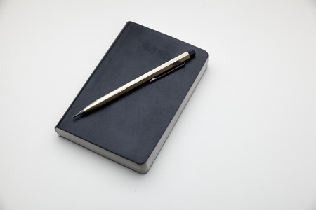 memo book and pencil on white backgroundの写真素材
