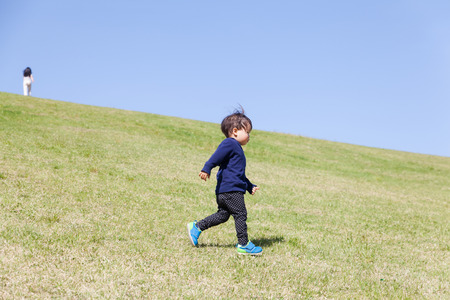 a boy playing on green hillの写真素材