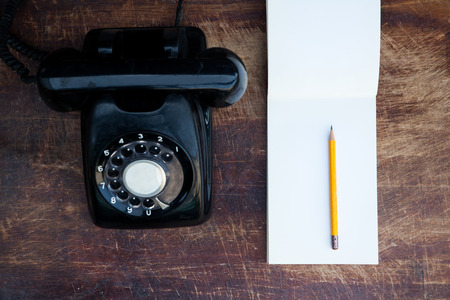 vintage telephone and memo pad on rustic tableの写真素材