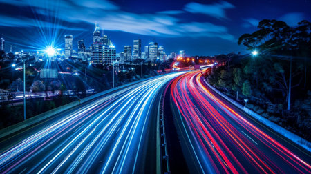 Stunning nighttime cityscape featuring vibrant light trails from busy highway traffic. The dynamic urban skyline showcases modern architecture against a clear night sky.の素材