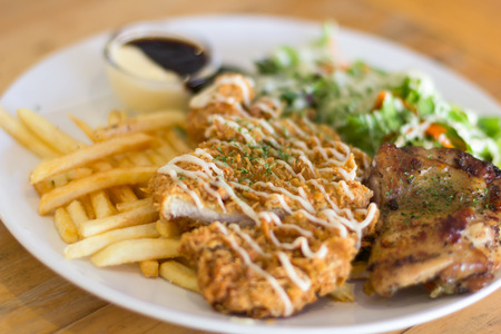 Fried pork chop, boiled potatoes and vegetable saladの写真素材