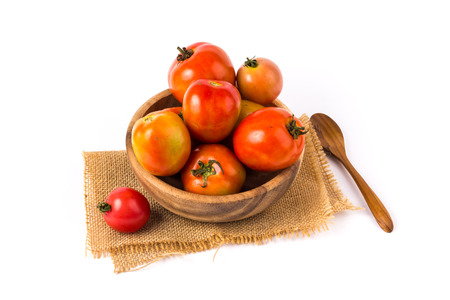 Tomatoes in a wooden bowl on a white background.の写真素材