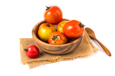 Tomatoes in a wooden bowl on a white background.の写真素材