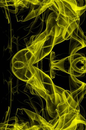 Yellow smoke on black background, movement of white smokeの写真素材