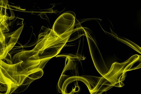 Yellow smoke on black background, movement of white smokeの写真素材