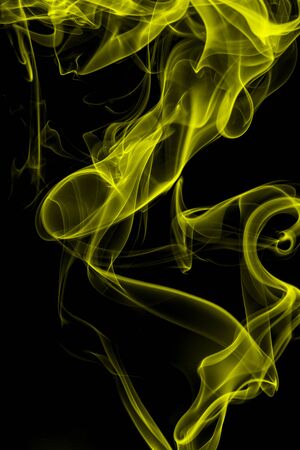 Yellow smoke on black background, movement of white smokeの写真素材