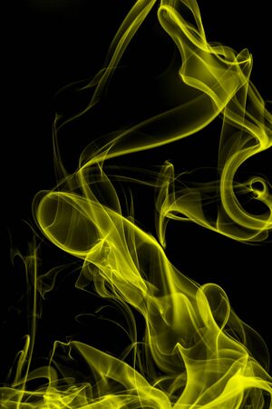 Yellow smoke on black background, movement of white smokeの写真素材