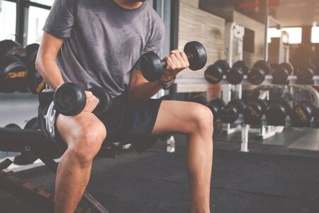 Closeup of a thin man doing exercises with dumbbell. Fitness muscular body. Fitness conceptの写真素材