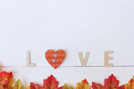 Love day concept. The wooden text remain to valentine's day with maple leaf and white background.valentine day, february14の写真素材