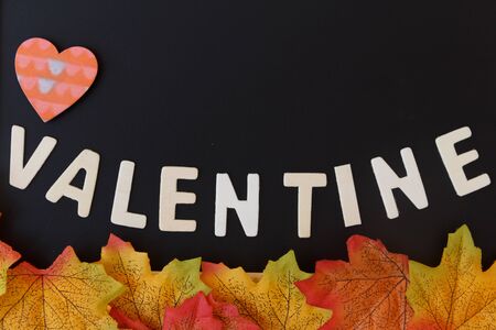 Love day concept. The wooden text remain to valentine's day with maple leaf and black background.valentine day, february14の写真素材
