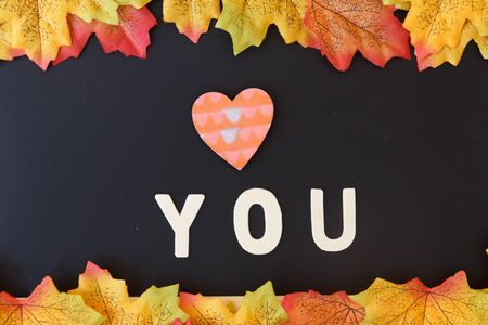 Love day concept. The wooden text remain to valentine's day with maple leaf and black background.valentine day, february14の写真素材