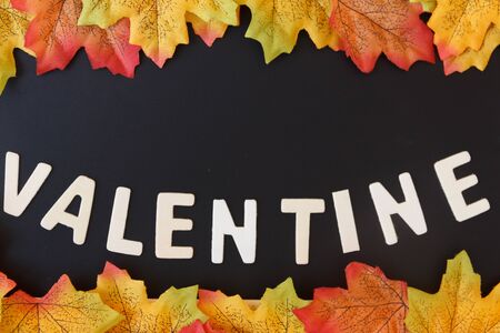 Love day concept. The wooden text remain to valentine's day with maple leaf and black...