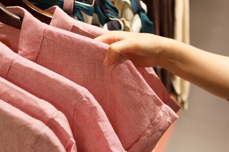 Close up of woman hand choosing a T-Shirt.の写真素材
