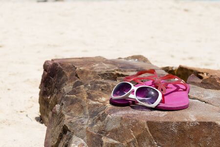 Summer vacation with  glasses and pink shoes on the rock.の写真素材