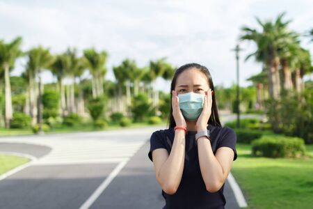 Sport woman in medical protective mask relaxing in the park.  campaign to use protective mask from COVID19の写真素材