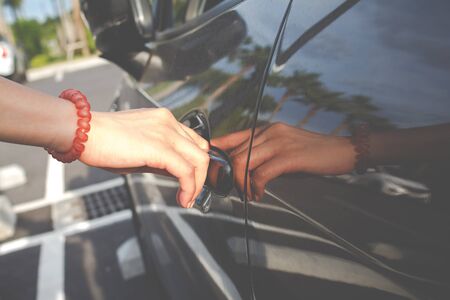 Close up of a woman opens car's door.の写真素材