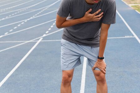 Sport man suffering from chest pain heart attack after running. Healthcare and medical concept.の写真素材