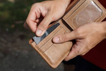  CLose up of a man hands as he is getting a credit card out of his wallet