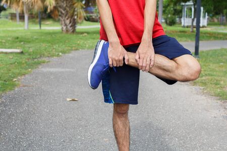 Young man runner warm up before run - workout concept