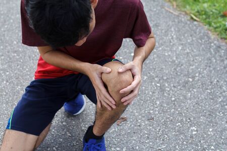 Close up of Sport man suffering with pain on sports running knee injury after running.Injury from...