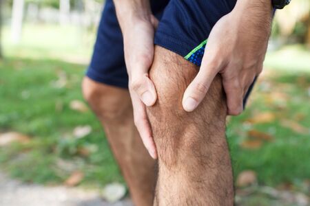 Close up of Sport man suffering with pain on sports running knee injury after running.Injury from...