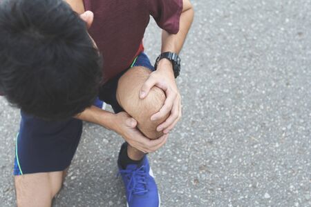 Close up of Sport man suffering with pain on sports running knee injury after running.Injury from workout concept.の写真素材